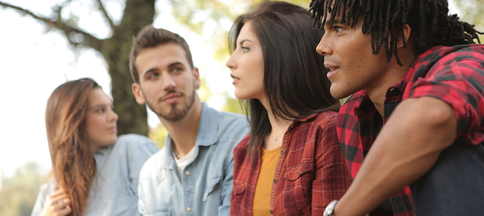 young people sitting in green forest