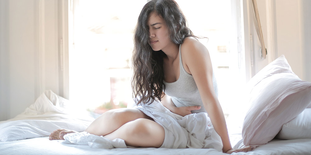 photo of a woman in bed experiencing diarrhea
