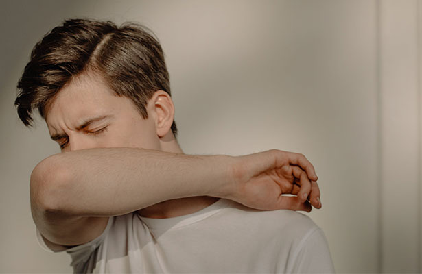 photo of a man covering his mouth after vomiting