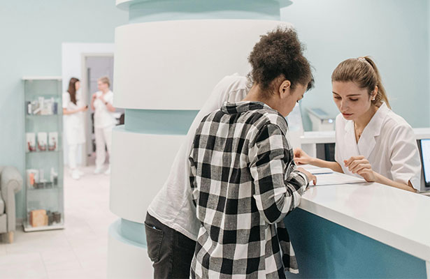 couple looking at documents in reception of medical center
